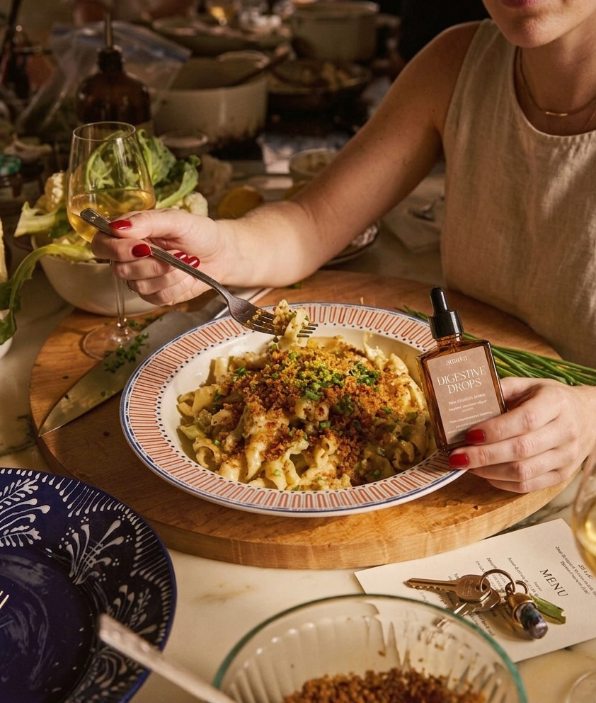 Woman at a dinner table with a plate of food and amara digestive drops.